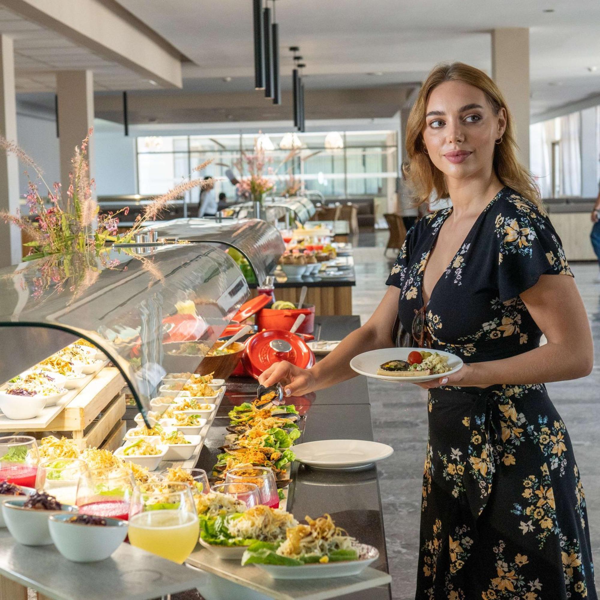 Radisson Blu Resort Al Hoceima Exterior photo A woman selecting food from a buffet