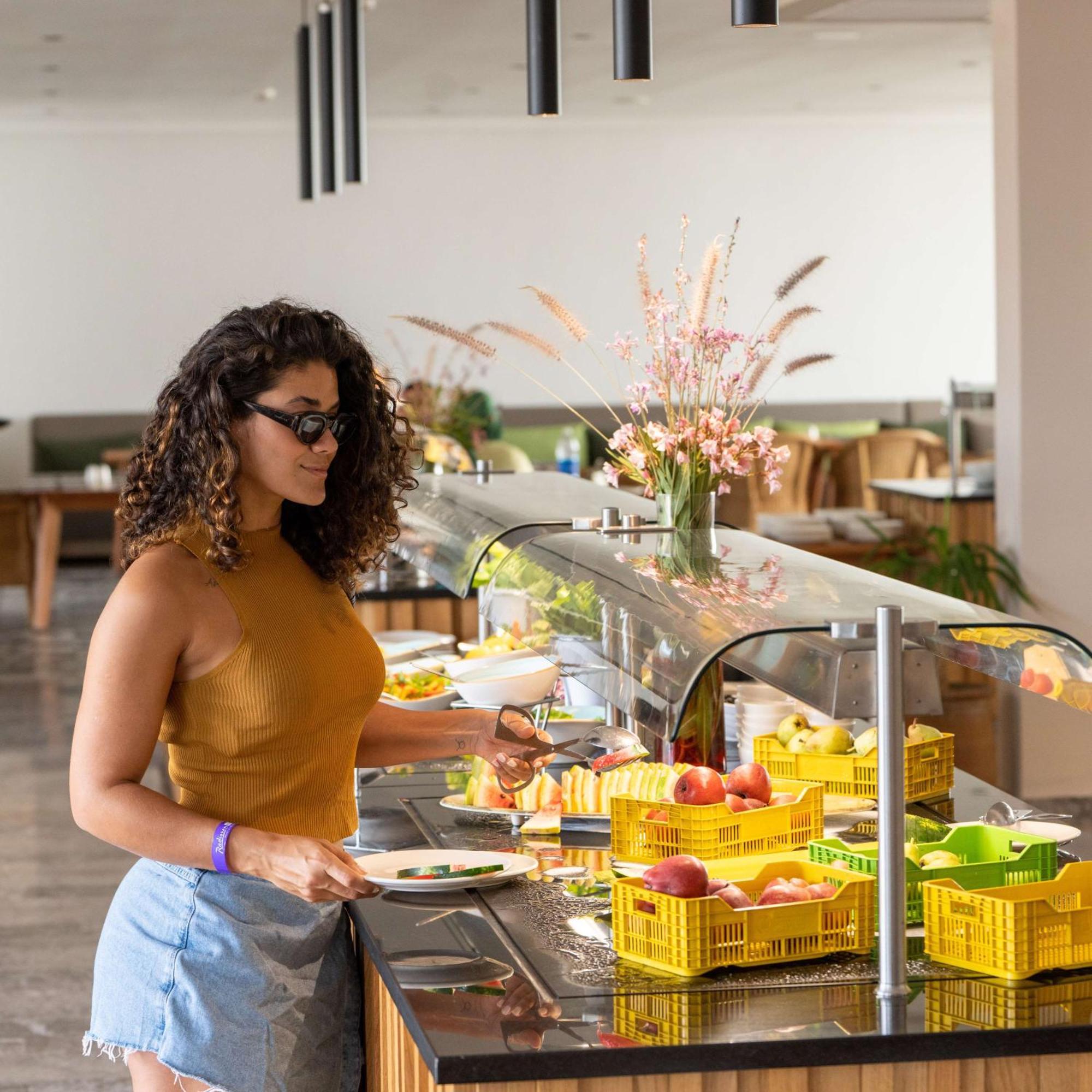 Radisson Blu Resort Al Hoceima Exterior photo A woman selecting food from a buffet